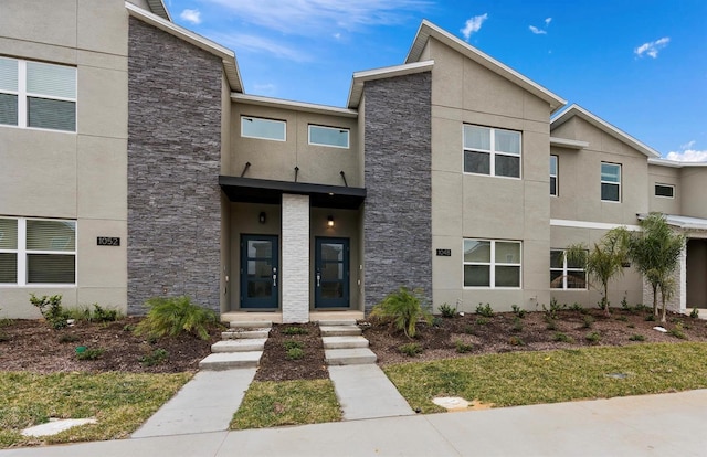 view of front of house with stone siding and stucco siding