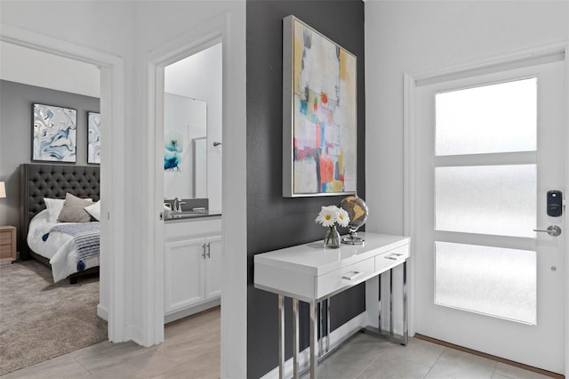 entryway featuring light tile patterned flooring, a healthy amount of sunlight, and light colored carpet