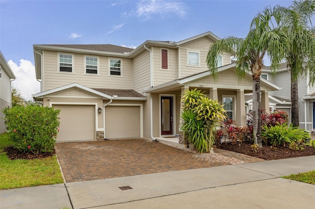 view of front facade with a garage and decorative driveway