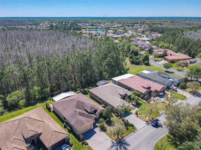 drone / aerial view featuring a residential view and a wooded view