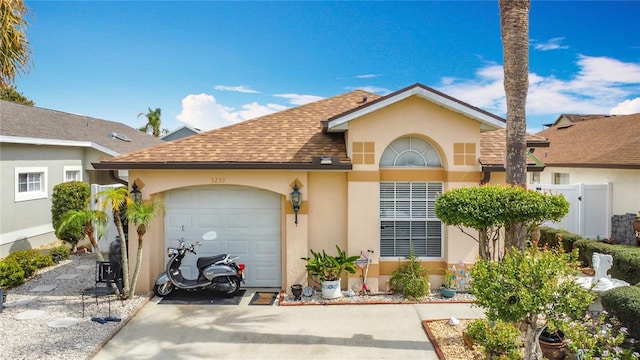 view of front of house featuring a shingled roof, concrete driveway, an attached garage, fence, and stucco siding