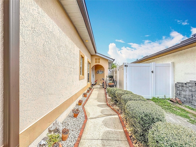 view of home's exterior featuring fence, a gate, and stucco siding