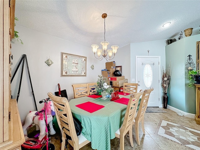 dining room with light tile patterned floors, baseboards, a chandelier, and a textured ceiling