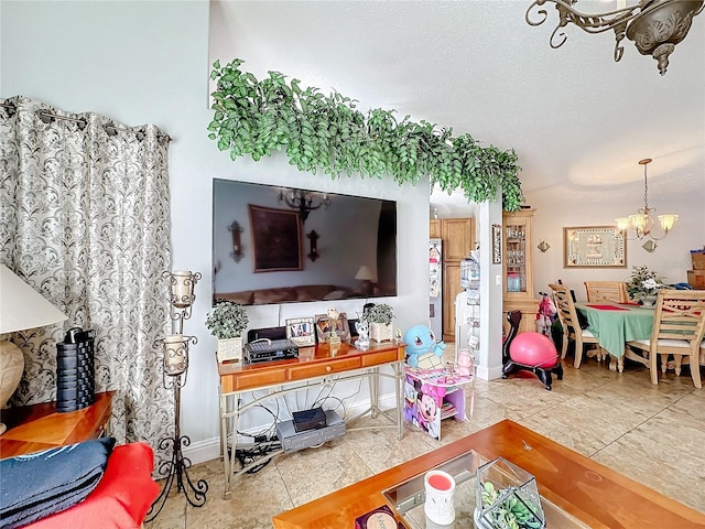 living room with baseboards, a chandelier, a textured ceiling, and tile patterned floors