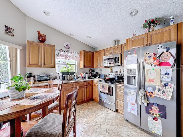 kitchen with light tile patterned floors, stainless steel appliances, and brown cabinetry