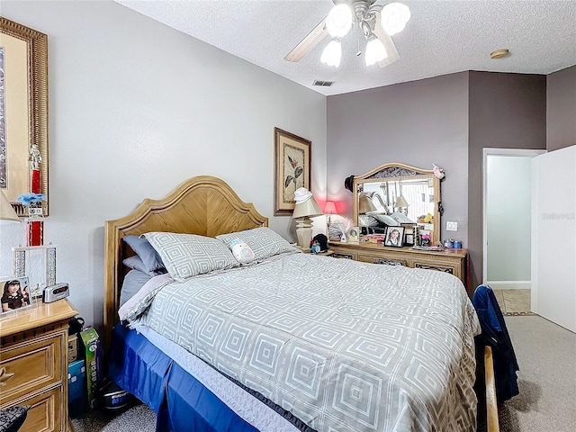 carpeted bedroom with visible vents, ceiling fan, and a textured ceiling