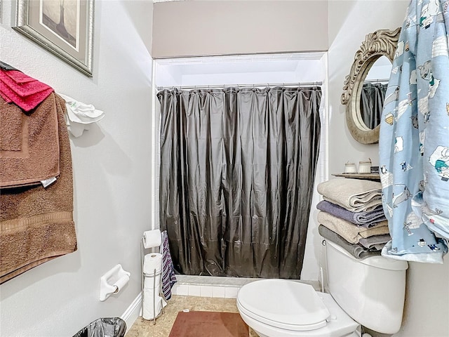 full bath with baseboards, a shower stall, and toilet