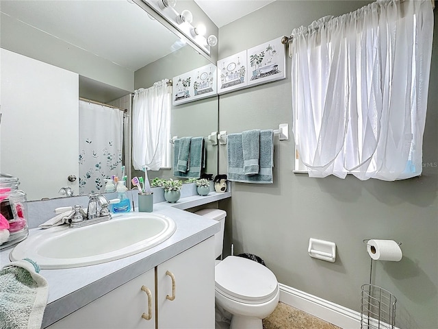 full bath with vanity, toilet, and baseboards