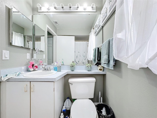 full bath with toilet, vanity, and visible vents