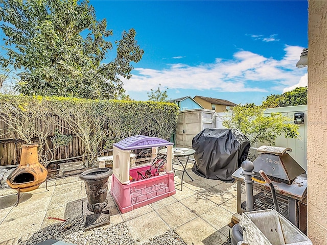 view of patio featuring a fire pit, grilling area, and a fenced backyard