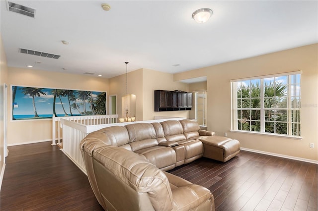 living area featuring dark wood-type flooring, visible vents, and baseboards