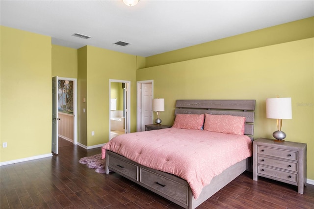 bedroom with ensuite bath, wood finished floors, visible vents, and baseboards