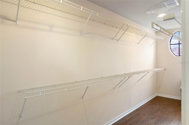 spacious closet featuring dark wood-style floors and visible vents