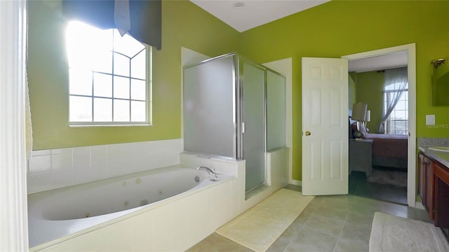 bathroom with a jetted tub, a stall shower, tile patterned flooring, and vanity