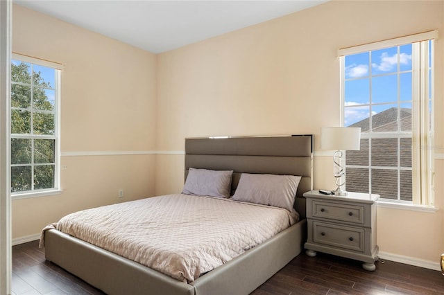 bedroom featuring multiple windows, baseboards, and dark wood-style flooring