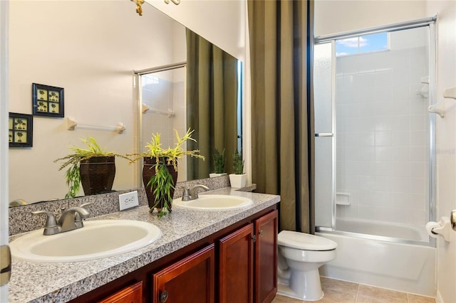 full bath with double vanity, tile patterned flooring, a sink, and toilet