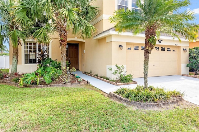 view of front of property featuring a garage, driveway, a front lawn, and stucco siding