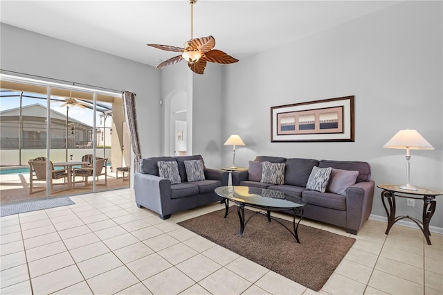 living room with a ceiling fan, baseboards, and light tile patterned floors