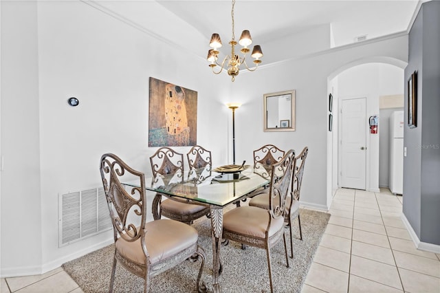 dining space with arched walkways, visible vents, baseboards, and light tile patterned floors