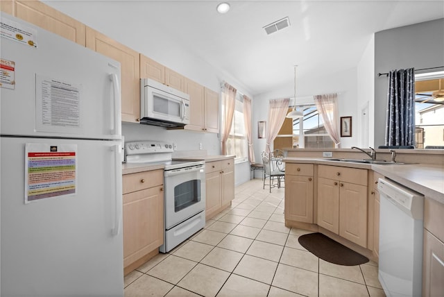 kitchen with light countertops, visible vents, light brown cabinetry, a sink, and white appliances