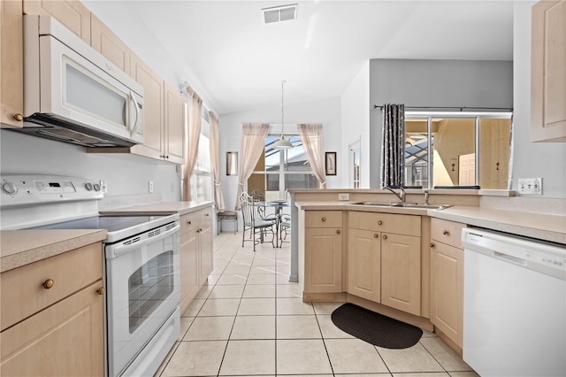 kitchen featuring white appliances, visible vents, light countertops, light brown cabinets, and a sink