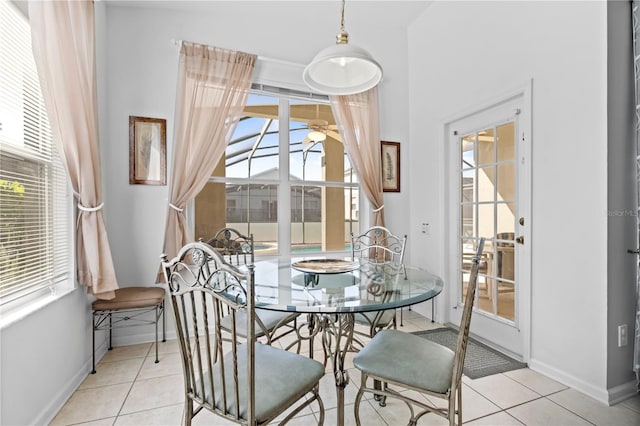 dining space featuring ceiling fan, baseboards, a wealth of natural light, and light tile patterned flooring