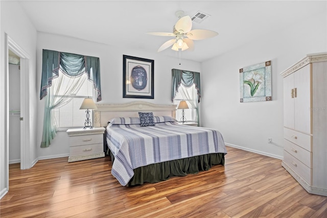 bedroom featuring visible vents, baseboards, and wood finished floors