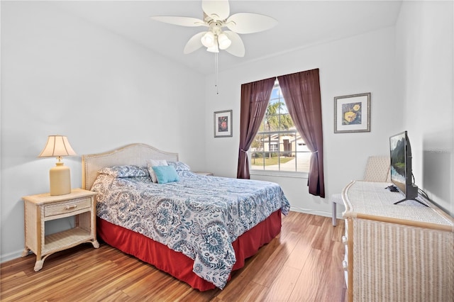 bedroom with light wood-style floors, baseboards, and a ceiling fan