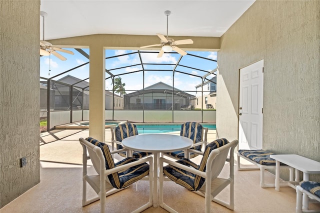 view of patio / terrace with glass enclosure, ceiling fan, a residential view, a pool with connected hot tub, and outdoor dining space