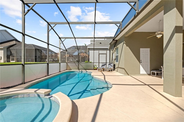 view of pool with a ceiling fan, glass enclosure, a residential view, a patio area, and a pool with connected hot tub