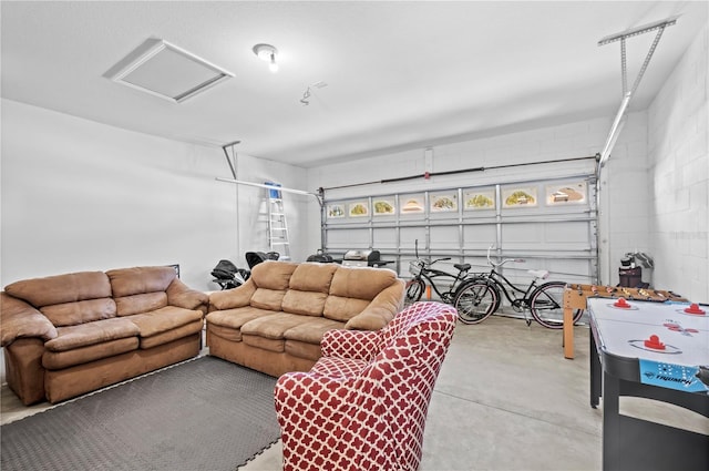 living area featuring a garage, attic access, and concrete floors