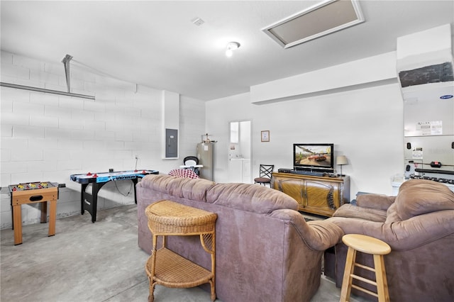 living room featuring water heater, concrete floors, electric panel, and attic access