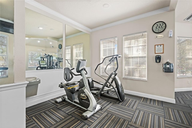 exercise area featuring baseboards, carpet flooring, and crown molding