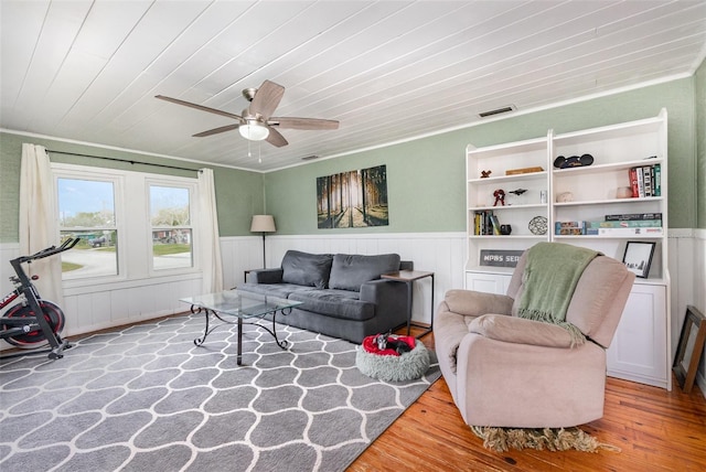 living area featuring wood ceiling, wainscoting, visible vents, and wood finished floors