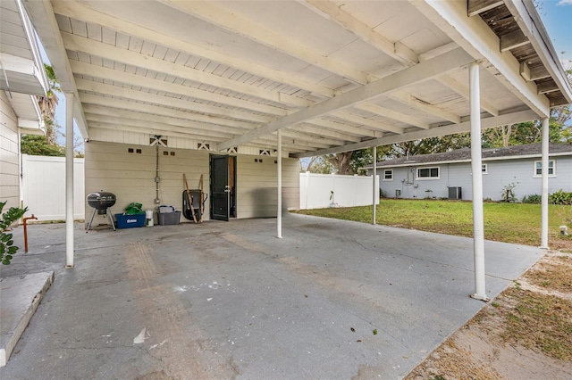 view of patio / terrace with a carport, central AC, and fence