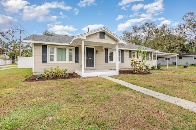 bungalow with covered porch, a front lawn, and roof with shingles