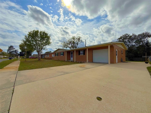 ranch-style home with an attached garage, driveway, and a front lawn