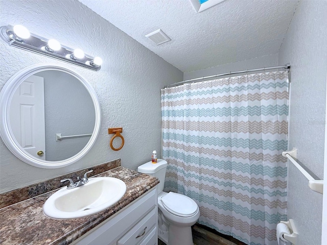 bathroom with visible vents, a textured wall, toilet, a textured ceiling, and vanity