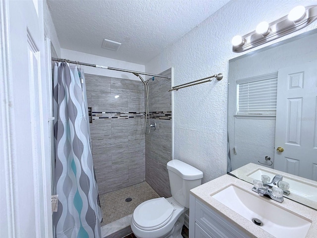 full bath with a textured ceiling, a textured wall, a tile shower, and toilet