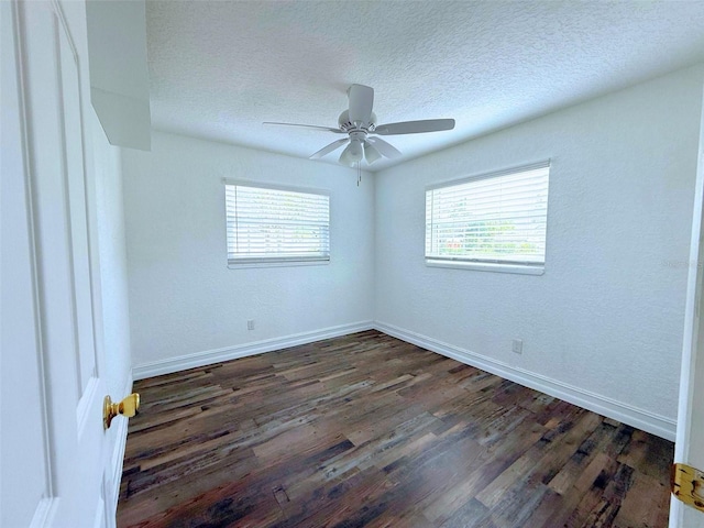 unfurnished room featuring a textured ceiling, ceiling fan, dark wood-style flooring, and baseboards