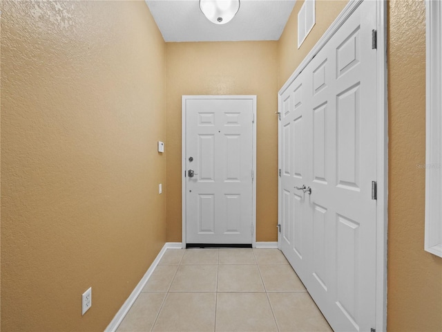 doorway to outside featuring light tile patterned floors, visible vents, and baseboards