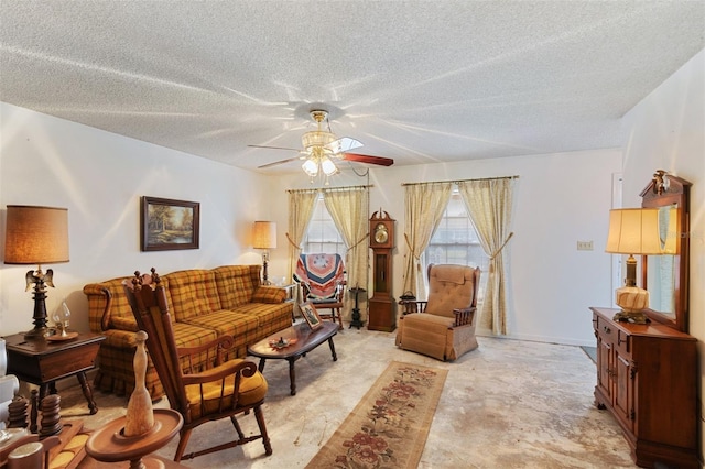 living room with ceiling fan, a textured ceiling, and baseboards