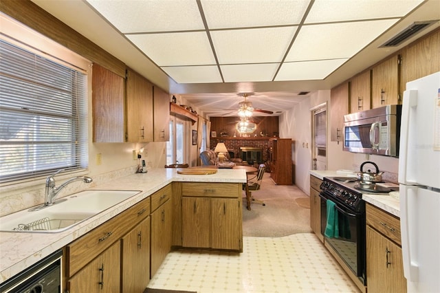 kitchen featuring visible vents, stainless steel microwave, black range with electric stovetop, freestanding refrigerator, and a sink