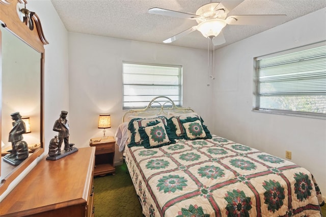 carpeted bedroom with a textured ceiling and a ceiling fan