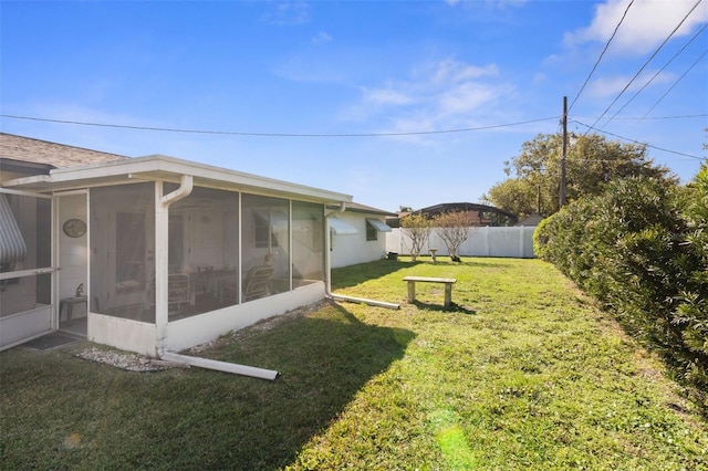 view of yard featuring a sunroom and a fenced backyard