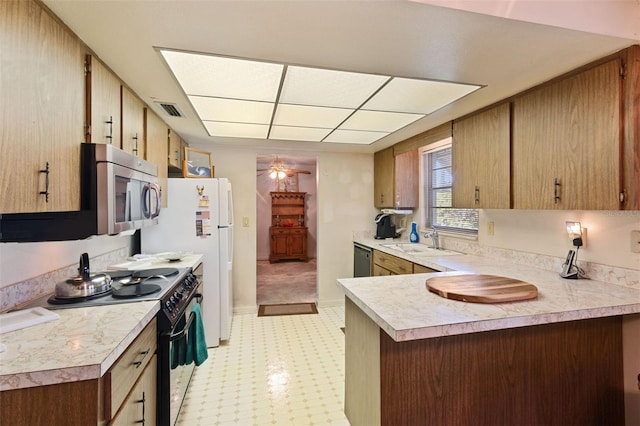 kitchen with visible vents, a ceiling fan, appliances with stainless steel finishes, light countertops, and a sink