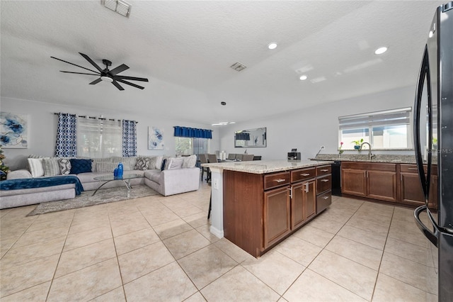 kitchen with light tile patterned floors, visible vents, open floor plan, and freestanding refrigerator