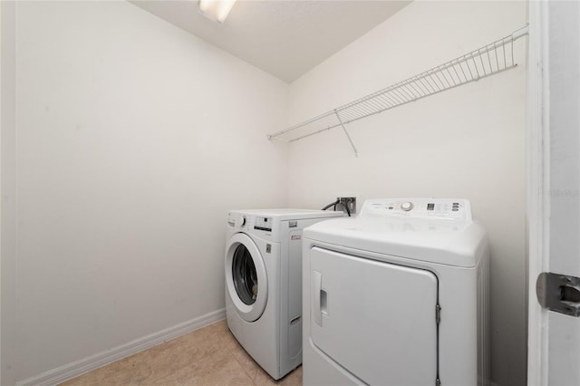 laundry area featuring laundry area, independent washer and dryer, baseboards, and light tile patterned floors