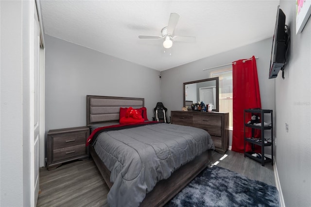 bedroom featuring ceiling fan, baseboards, and wood finished floors