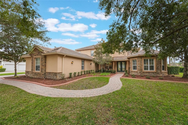 ranch-style home with stone siding, a front lawn, french doors, and stucco siding